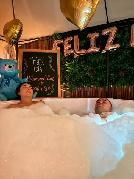 Pareja en el jacuzzi decorado para su celebración en Ixora Spa Bucaramanga